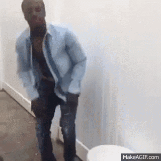 a man is standing in front of a toilet in a bathroom .