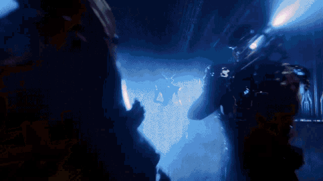 a blurred image of a person in a dark room with a light shining on them