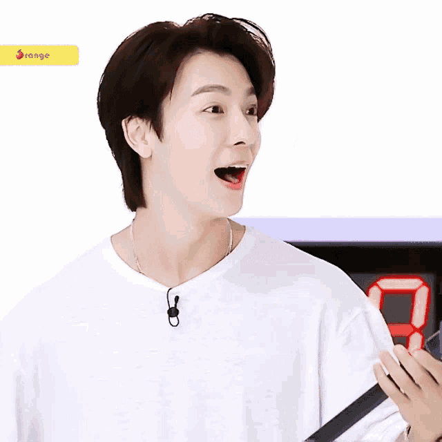 a young man is laughing in front of a digital clock that says 98