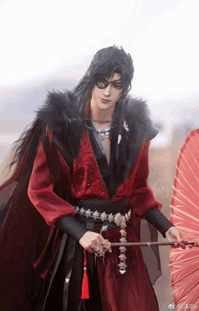 a man in a red and black outfit is holding an umbrella