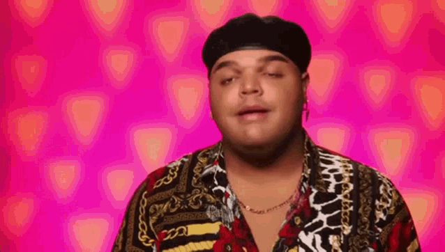 a man wearing a hat and a colorful shirt is making a funny face .