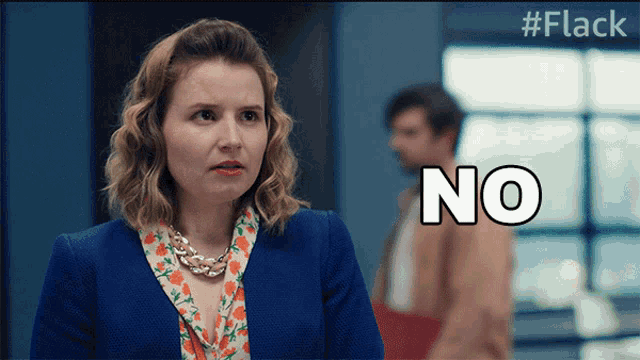 a woman in a blue jacket says no in front of a window