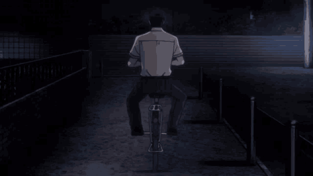 a man is riding a bike in the dark