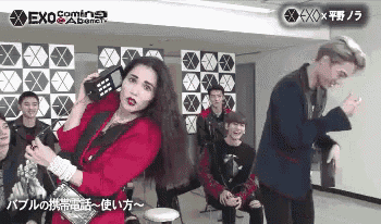 a woman in a red dress is talking on a phone while a man in a suit looks on