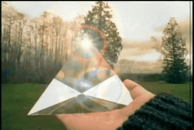 a person is holding a glass pyramid in their hand