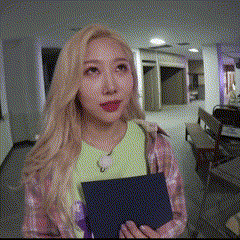 a woman in a plaid shirt is holding a book in her hands