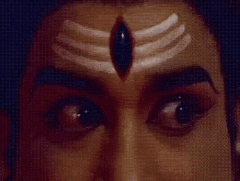 a close up of a man 's face with a symbol on his forehead and a third eye .