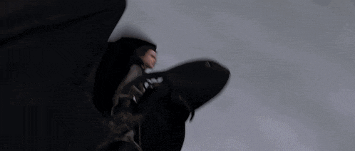 a person is flying through the air in a dark room with a blurred background .