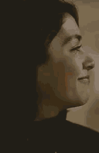 a close up of a woman 's face with her eyes closed smiling .