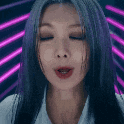 a woman with purple hair is making a funny face with her eyes closed
