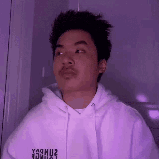 a man with a mustache is wearing a white hoodie .