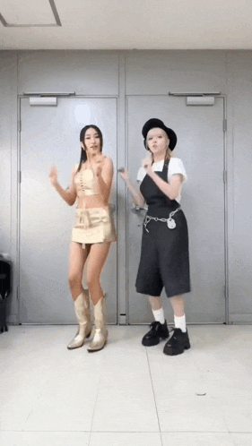 two women are standing next to each other in a room and dancing .