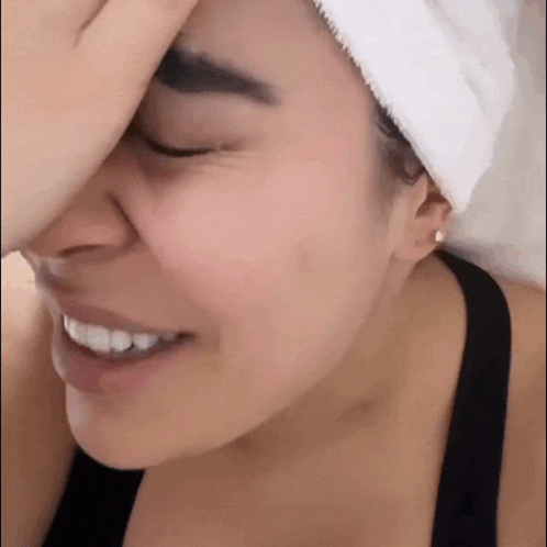 a woman with a towel wrapped around her head covering her face