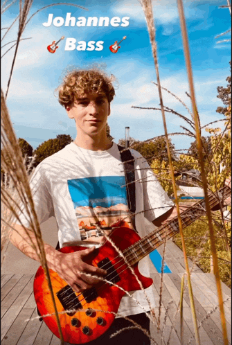 a young man is holding a red guitar with the name johannes on the bottom