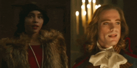a woman in a fur coat is standing next to a man in a costume