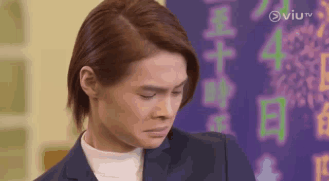a man in a suit and turtleneck is making a funny face .