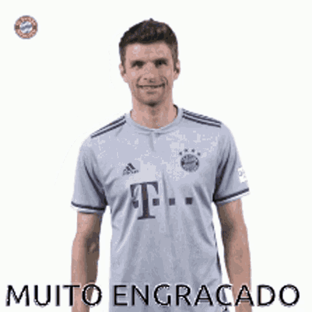 a man in a gray adidas shirt is making a gesture with his hand