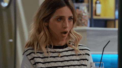 a woman with a surprised look on her face wearing a striped sweater