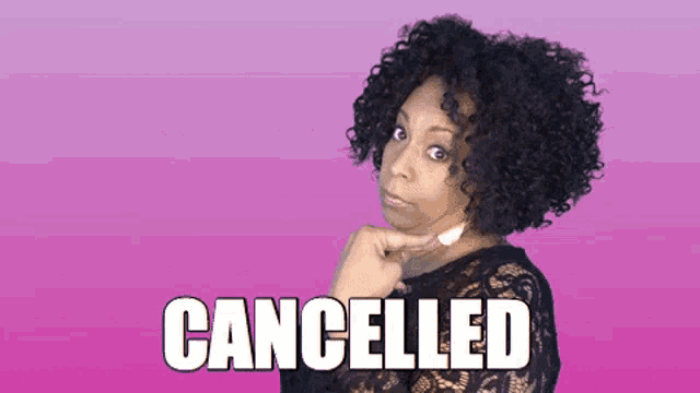a woman with curly hair has the word cancelled on her face