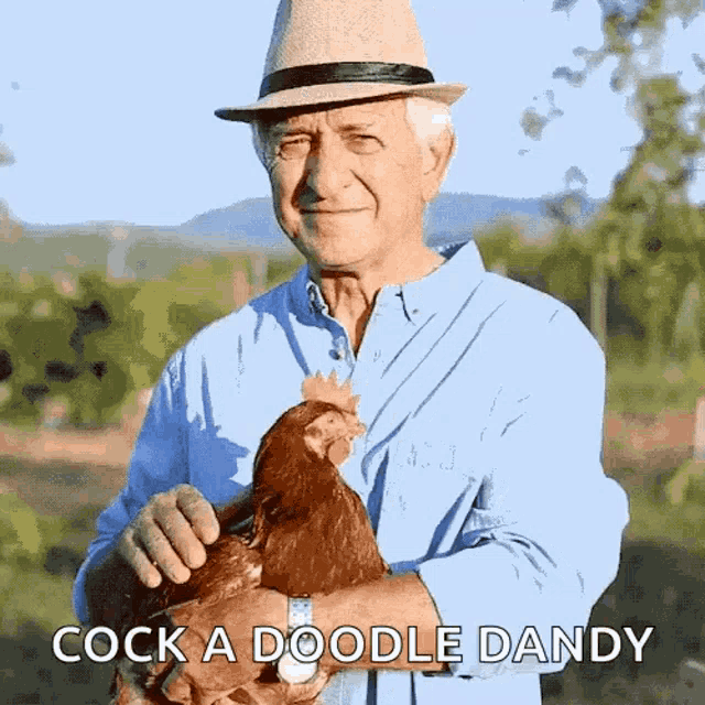 a man in a hat is holding a chicken in his hands with the words cock a doodle dandy below him