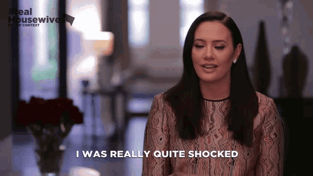 a woman says i was really quite shocked in front of a real housewife logo