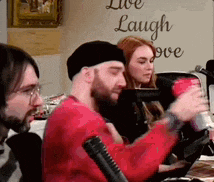 a group of people are sitting in front of a sign that says live laugh love