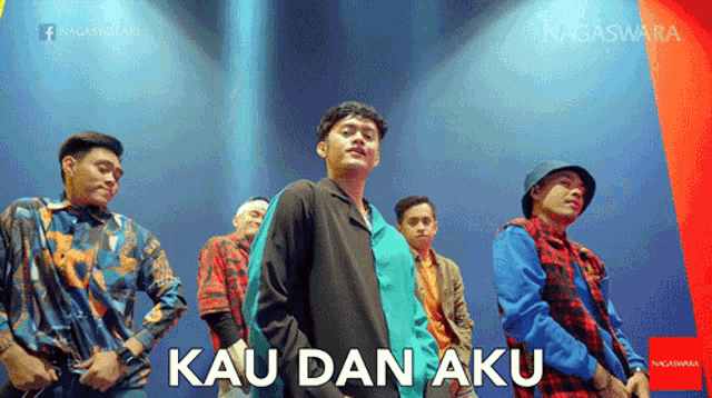 a group of young men are standing in front of a sign that says " kau dan aku " on it