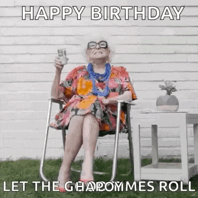 an elderly woman is sitting in a folding chair holding a glass of wine .