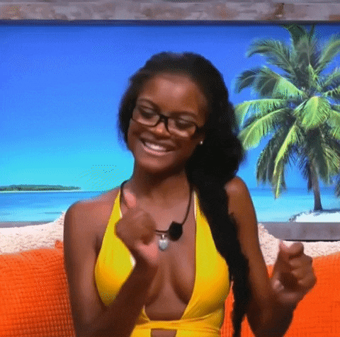 a woman in a yellow bikini and glasses is smiling while sitting on a couch .