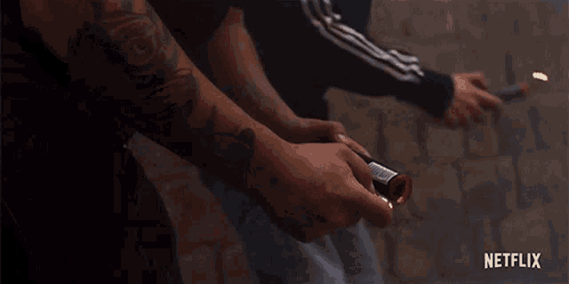 a close up of a person holding a knife in front of a brick wall with netflix written on the bottom .