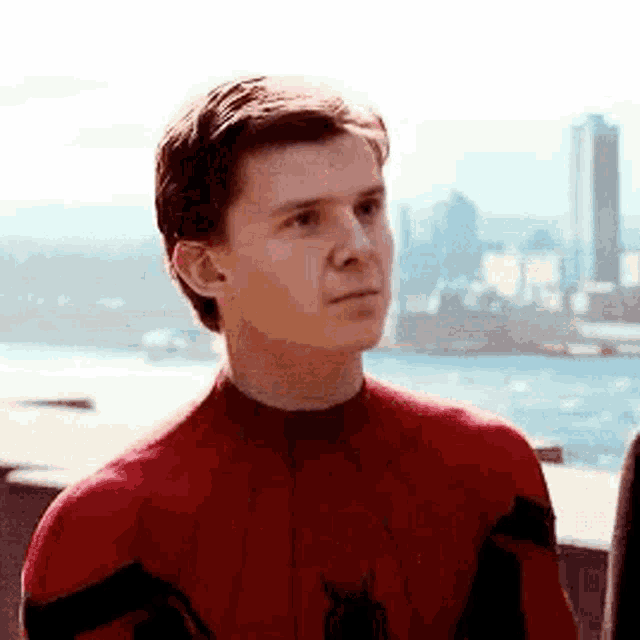 a close up of a man in a spiderman costume looking at something .