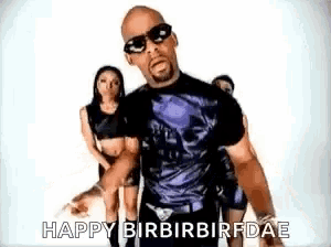 a man wearing sunglasses and a skull shirt says happy birbirbirfdae in front of two women