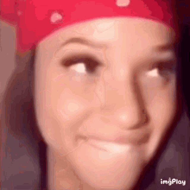 a woman wearing a red bandana making a funny face .