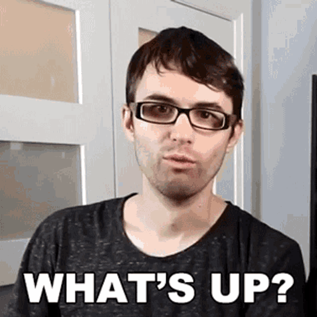 a man wearing glasses and a black shirt says what 's up ?