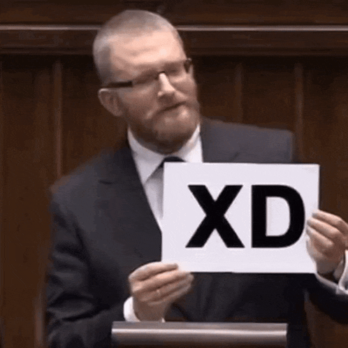 a man in a suit and tie is holding a sign with the word xd on it .