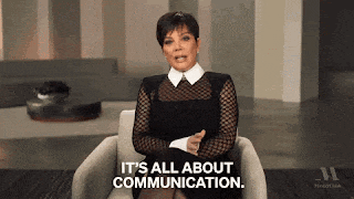 a woman in a black dress is sitting in a chair and says it 's all about communication .