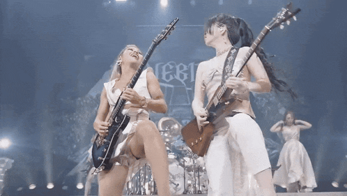 two women playing guitars on a stage with a sign that says ' eeri ' on it