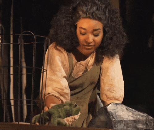 a woman holds a stuffed frog in her hands