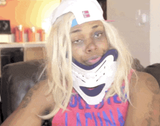 a woman wearing a pink shirt and a white hat has a neck brace around her neck