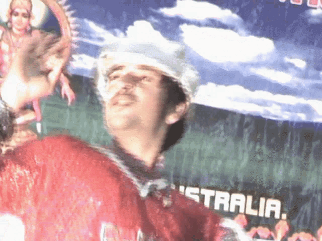 a man in a red shirt is standing in front of a sign that says australia