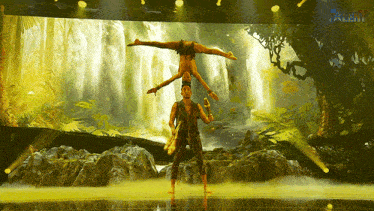 a man and a woman perform acrobatics in front of a waterfall with talent written on the bottom right