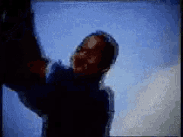 a blurry picture of a man 's face with a blue sky in the background
