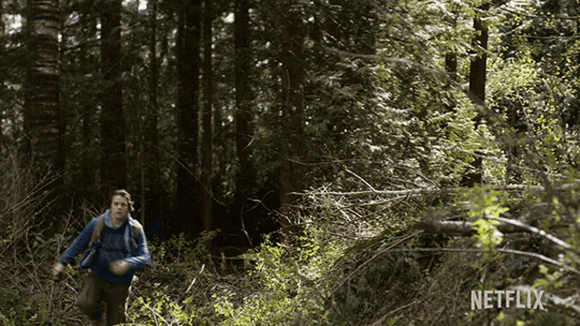 a man running through a forest with a netflix logo in the background