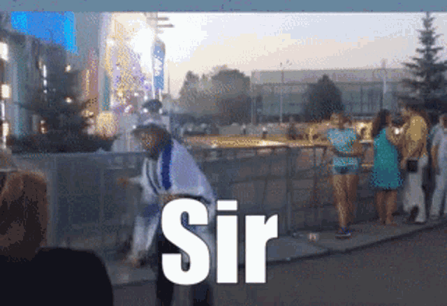 a man in a cowboy hat is standing in front of a crowd and the word sir is visible