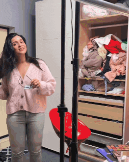 a woman standing in front of a closet full of clothes