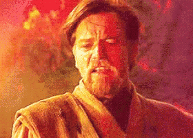a man with a beard is standing in front of a fire and making a funny face .