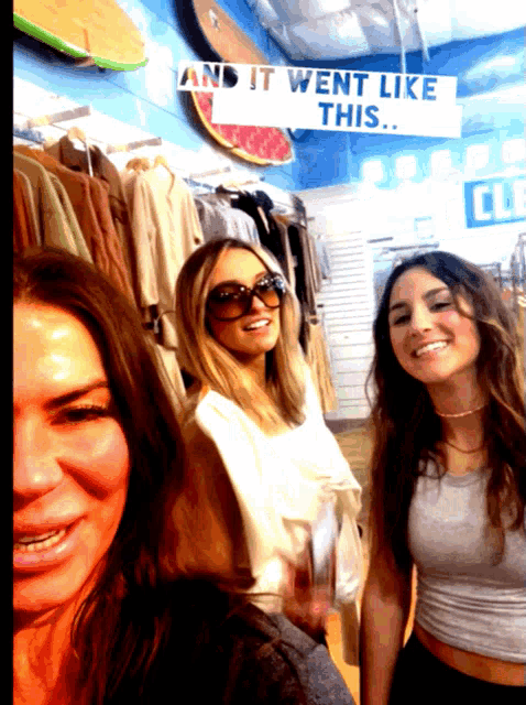 three women are posing for a picture in front of a sign that says and it went like this