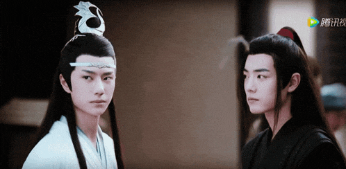 two young men are standing next to each other and one of them is wearing a white robe