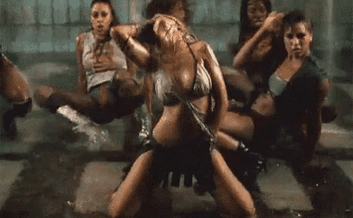 a group of women are dancing in the rain and one of them is holding a cell phone .
