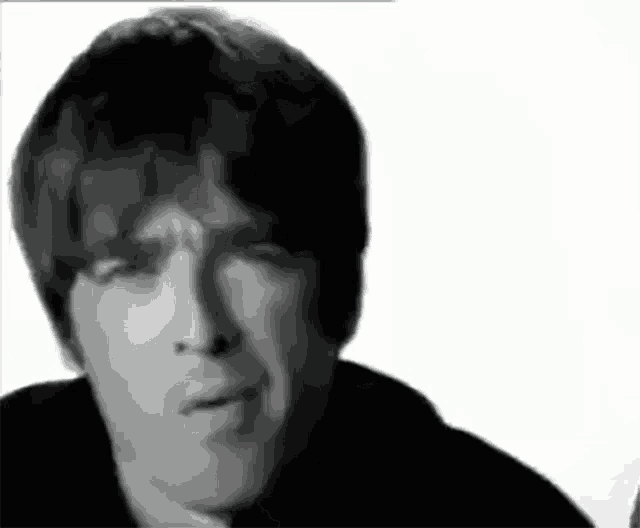 a close up of a man 's face with a serious look on his face in a black and white photo .